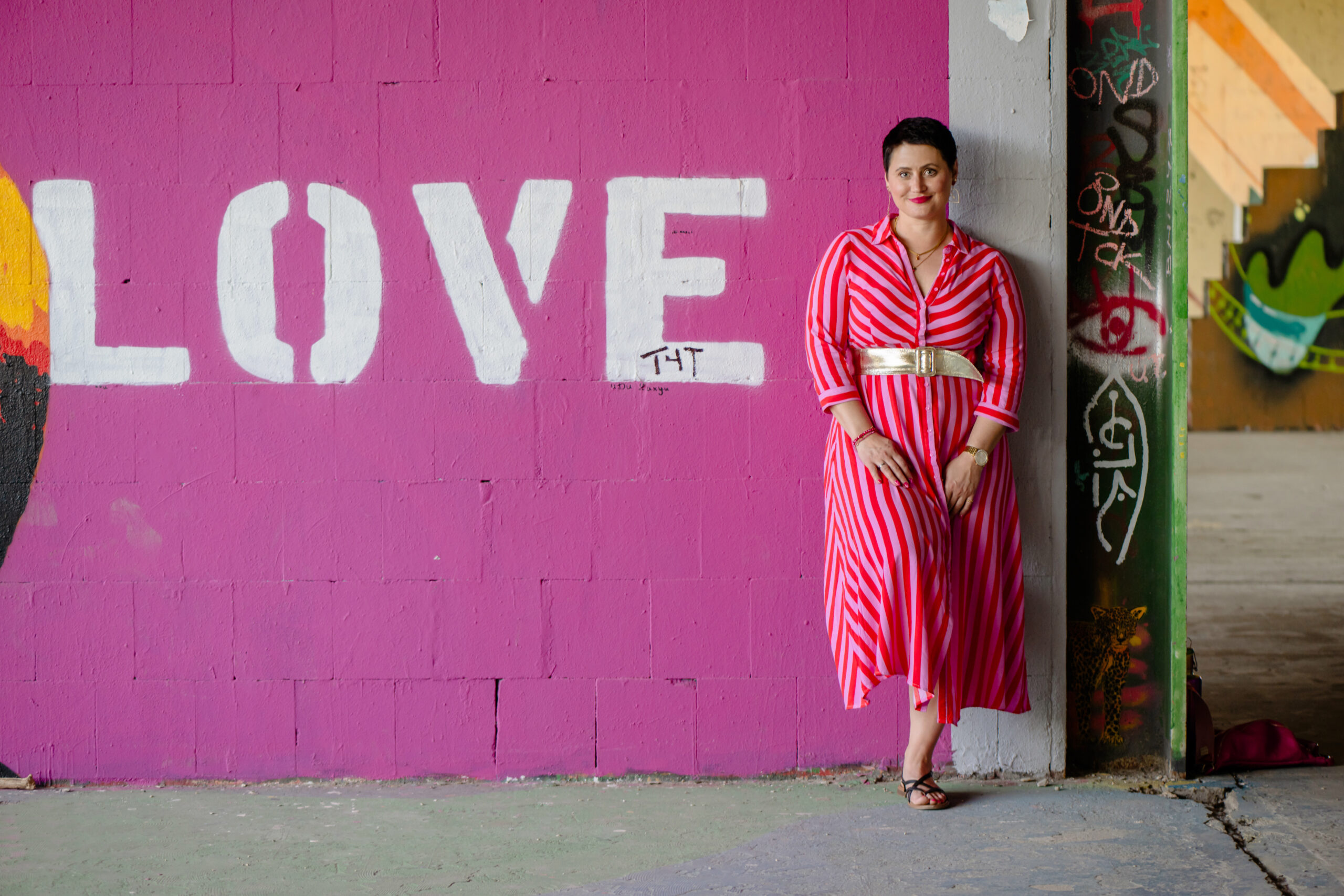 Coaching für Frauen_Ehrliche Alltagseinblicke aus dem Leben einer Coachin & Mutter – zum Mitnehmen & Reflektieren Luisa Riffel ist Life Coach für Frauen Online und Persönlich in Charlottenburg. Auf dem Bild lehnt sich an eine Wand auf der in großen Buchstaben LOVE steht. Für mehr Selbstliebe und Vertrauen im Leben als Frau und Mutter